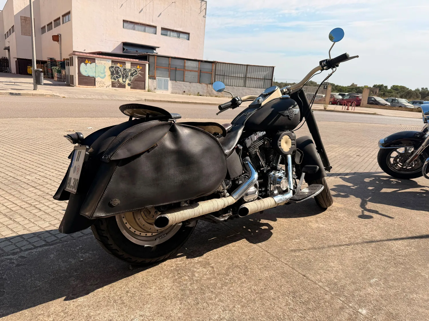 Harley-Davidson Fat Boy FL1 von schräg hinten rechts mit Ledertaschen und Doppelauspuff